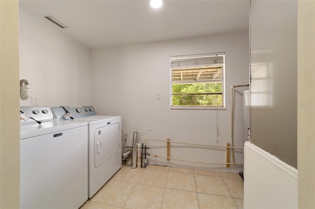 laundry room featuring light tile patterned floors and washer and clothes dryer