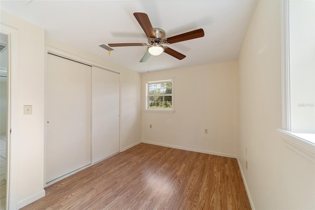 unfurnished bedroom featuring ceiling fan, light hardwood / wood-style flooring, and a closet