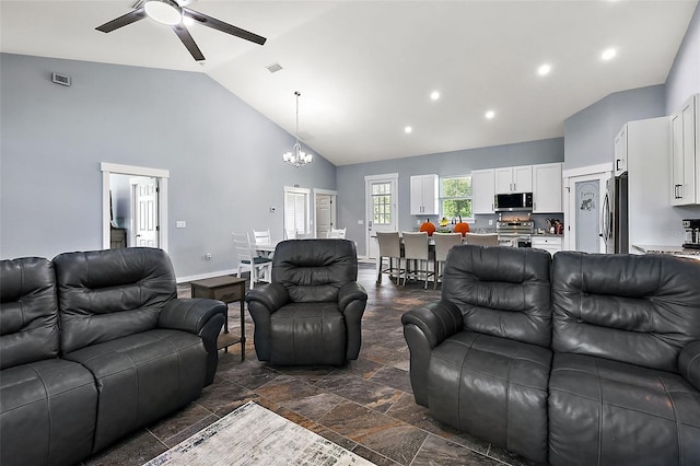 living room with ceiling fan with notable chandelier and high vaulted ceiling