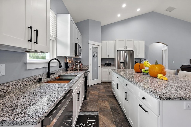 kitchen with white cabinets, stainless steel appliances, and a kitchen island