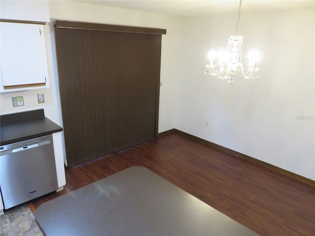 kitchen with pendant lighting, dark hardwood / wood-style floors, an inviting chandelier, and stainless steel dishwasher