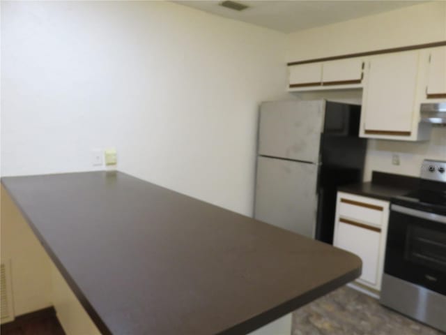 kitchen with white cabinets, stainless steel electric stove, white fridge, and extractor fan