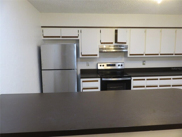 kitchen featuring appliances with stainless steel finishes, a textured ceiling, white cabinetry, and range hood