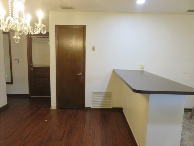 interior space with a chandelier and dark hardwood / wood-style flooring