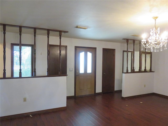 foyer entrance featuring a chandelier, dark hardwood / wood-style floors, and plenty of natural light