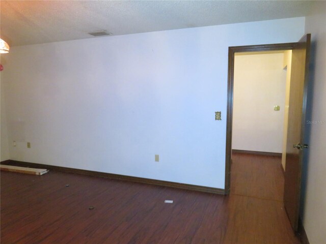 empty room featuring a textured ceiling and hardwood / wood-style floors