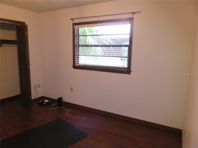 unfurnished bedroom featuring a closet and dark hardwood / wood-style floors