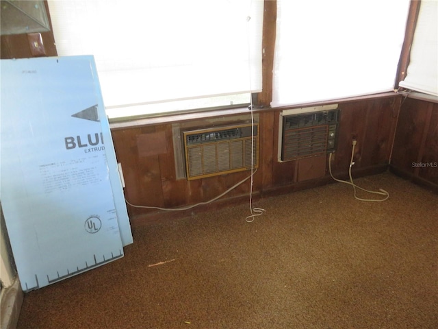 interior details featuring an AC wall unit, wooden walls, and carpet floors