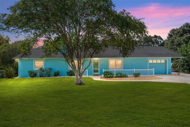 single story home with a garage and a lawn