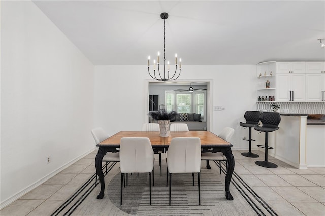 tiled dining area with ceiling fan with notable chandelier