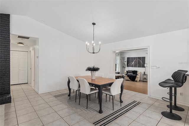 tiled dining area with vaulted ceiling and an inviting chandelier