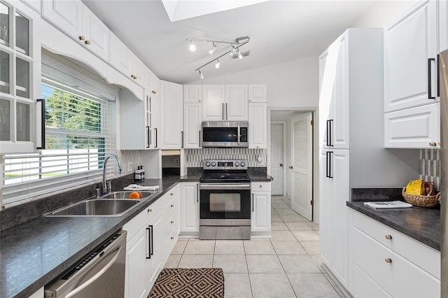 6212 NE 26th Ave, Ocala, FL 34479 - kitchen featuring appliances with stainless steel finishes, a sink, white cabinets, dark countertops, and lofted ceiling
