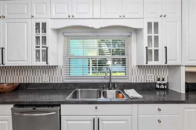 6212 NE 26th Ave, Ocala, FL 34479 - kitchen with stainless steel dishwasher, a sink, white cabinetry, dark countertops, and decorative backsplash