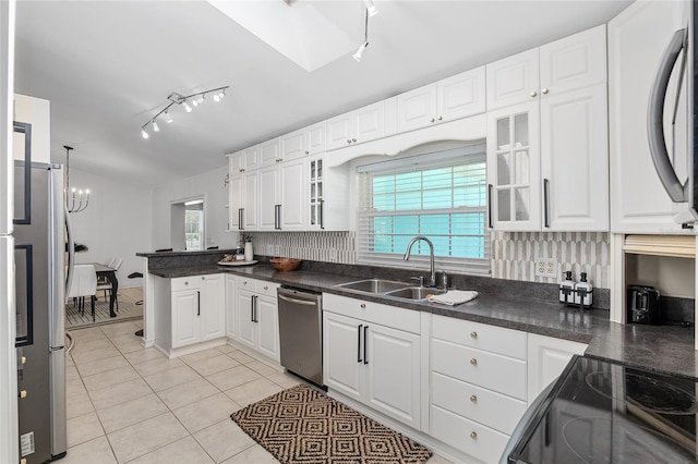 kitchen with white cabinets, appliances with stainless steel finishes, backsplash, and a healthy amount of sunlight