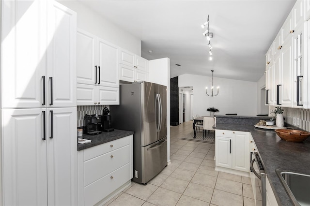 6212 NE 26th Ave, Ocala, FL 34479 - kitchen featuring dark countertops, appliances with stainless steel finishes, light tile patterned floors, white cabinets, and vaulted ceiling