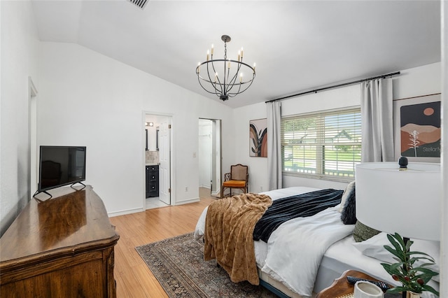 bedroom with vaulted ceiling, light hardwood / wood-style flooring, a chandelier, and ensuite bathroom