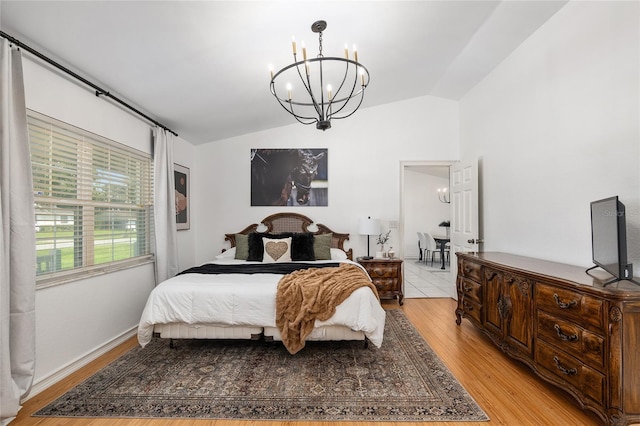 bedroom with vaulted ceiling, a notable chandelier, and light wood-type flooring