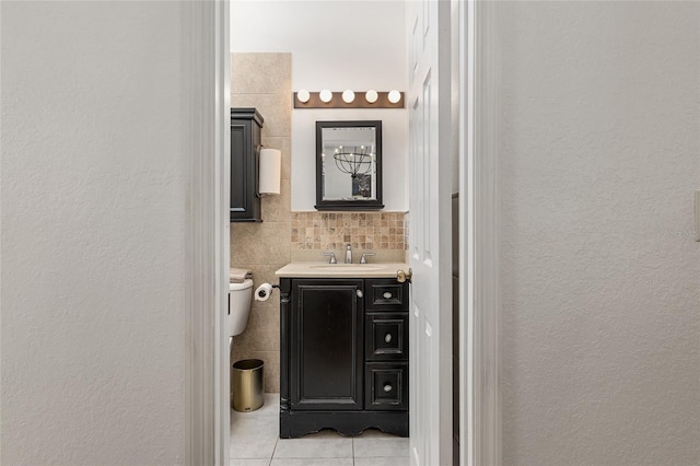 bathroom featuring toilet, tile patterned flooring, tile walls, and vanity