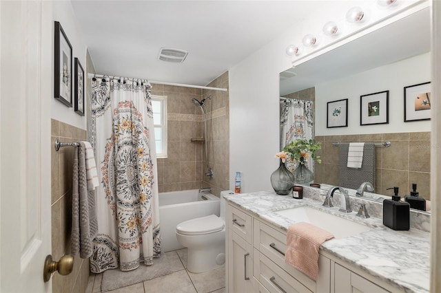 full bathroom featuring tile patterned flooring, toilet, shower / bathtub combination with curtain, tile walls, and vanity