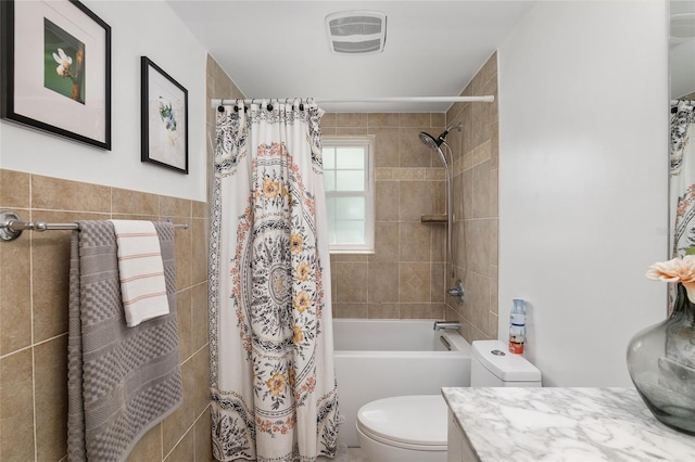 full bathroom with vanity, tile walls, toilet, and shower / bathtub combination with curtain