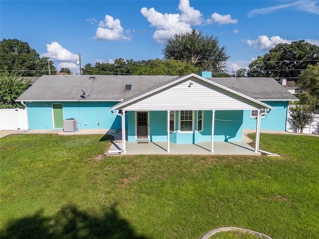 back of property with central air condition unit, a yard, and a patio area