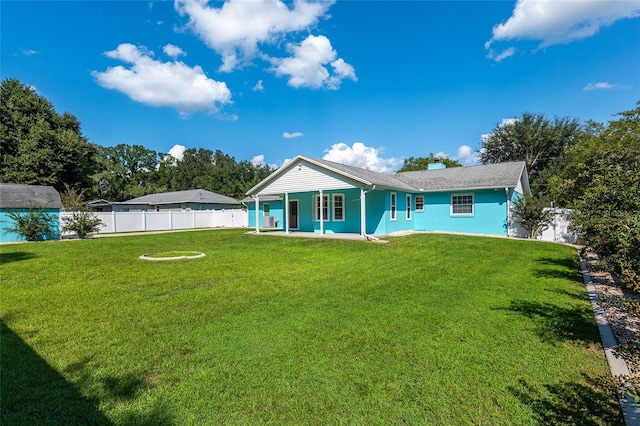 rear view of property with a yard