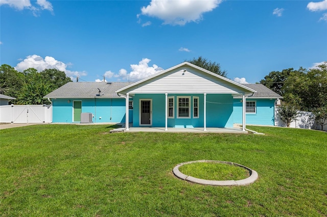 back of property with a yard, central AC, and covered porch