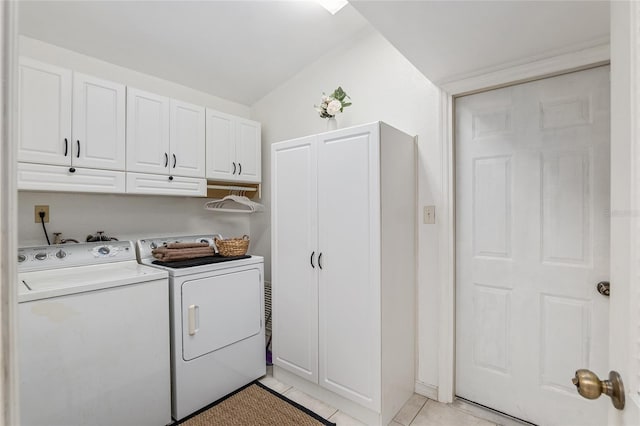 laundry room with light tile patterned flooring, washer and clothes dryer, and cabinets