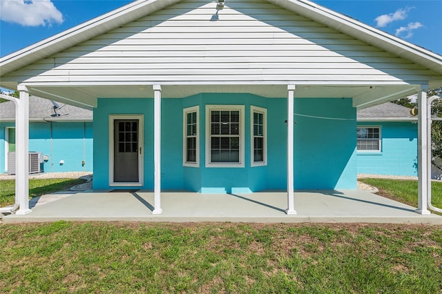 back of house featuring central AC and a lawn