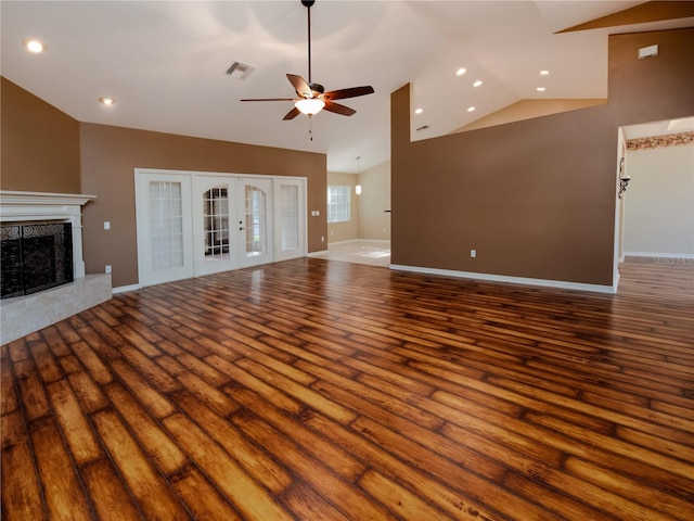 unfurnished living room with a premium fireplace, lofted ceiling, ceiling fan, and hardwood / wood-style flooring