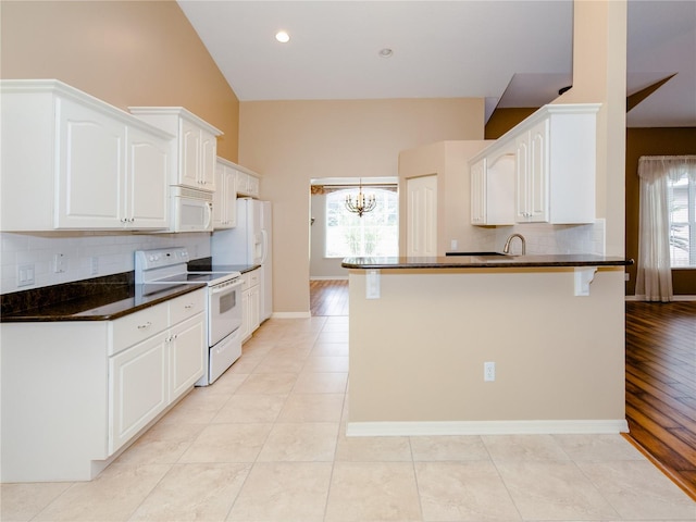 kitchen with white cabinets, light hardwood / wood-style flooring, white appliances, and a healthy amount of sunlight