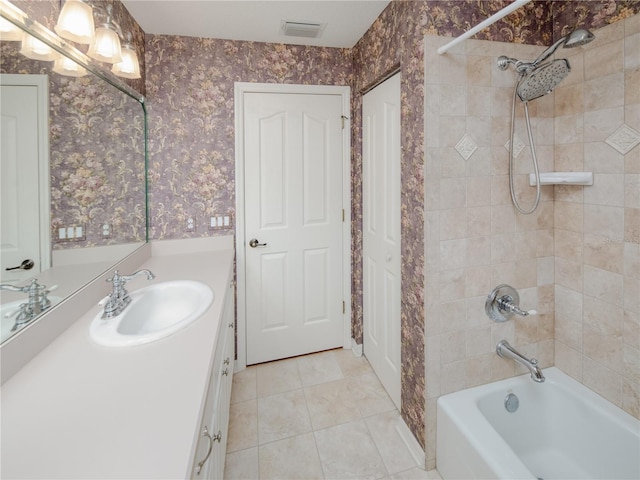 bathroom with vanity, tiled shower / bath combo, and tile patterned flooring