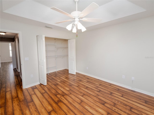 unfurnished bedroom with ceiling fan, hardwood / wood-style flooring, and a closet