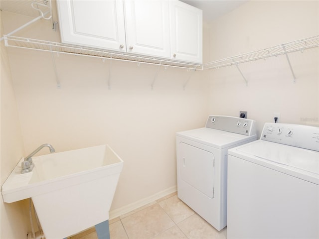 washroom featuring light tile patterned floors, sink, independent washer and dryer, and cabinets