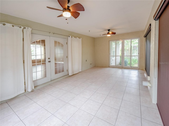 spare room featuring light tile patterned floors, ceiling fan, and french doors