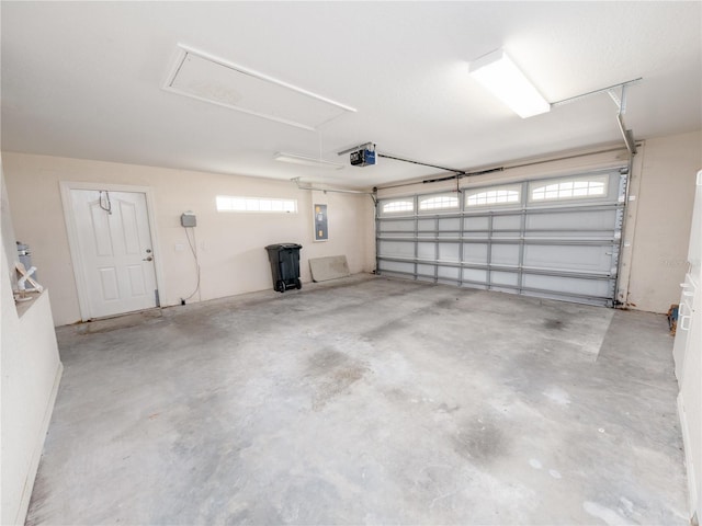 garage with a garage door opener and electric panel