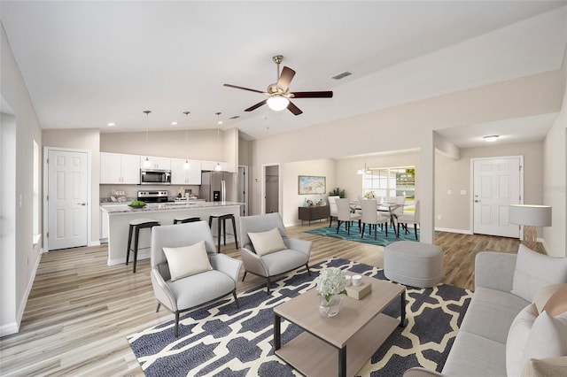 living room featuring ceiling fan, light wood-type flooring, and high vaulted ceiling