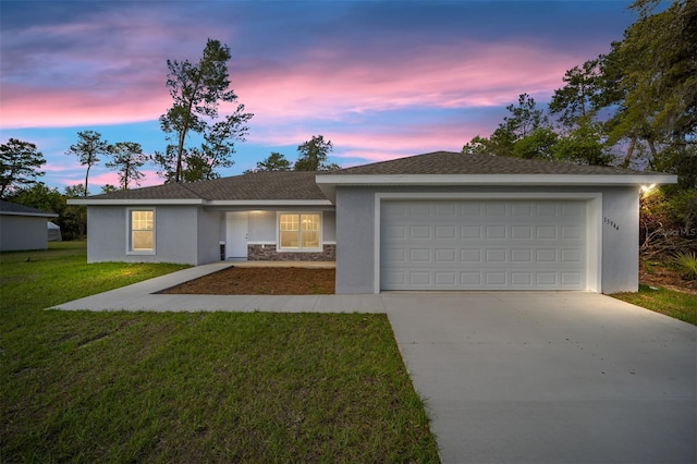 ranch-style house featuring a garage and a lawn