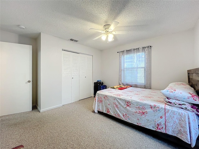 bedroom with a closet, carpet, ceiling fan, and a textured ceiling