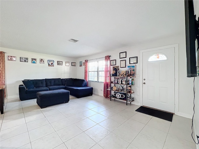 tiled living room featuring a textured ceiling