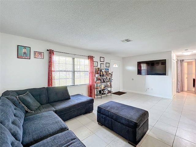 living room featuring a textured ceiling and light tile patterned flooring