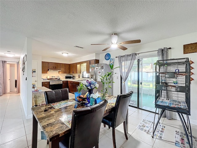 dining room featuring a textured ceiling, light tile patterned flooring, sink, and ceiling fan