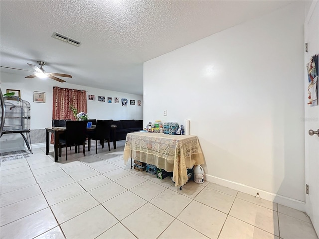 dining room featuring light tile patterned floors, baseboards, a textured ceiling, visible vents, and a ceiling fan