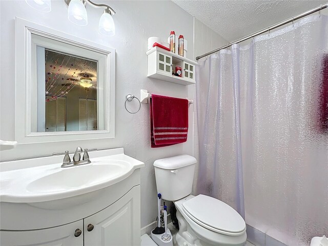 bathroom featuring vanity, toilet, a textured ceiling, and curtained shower