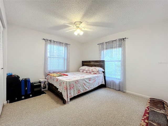 bedroom featuring ceiling fan, carpet floors, and a textured ceiling