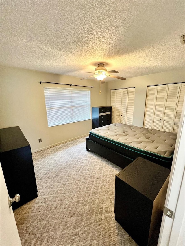 6789 SE 54th Ln, Ocala, FL 34472 - carpeted bedroom featuring multiple closets, a textured ceiling, and a ceiling fan