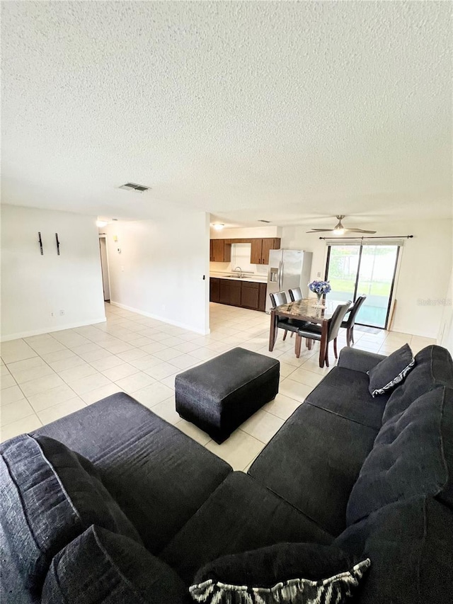 6789 SE 54th Ln, Ocala, FL 34472 - living area with light tile patterned floors, a textured ceiling, and a ceiling fan