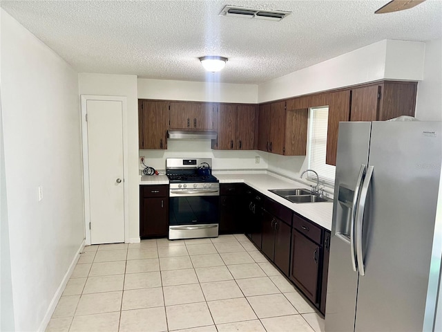 6789 SE 54th Ln, Ocala, FL 34472 - kitchen featuring stainless steel appliances, under cabinet range hood, light countertops, a textured ceiling, and light tile patterned floors