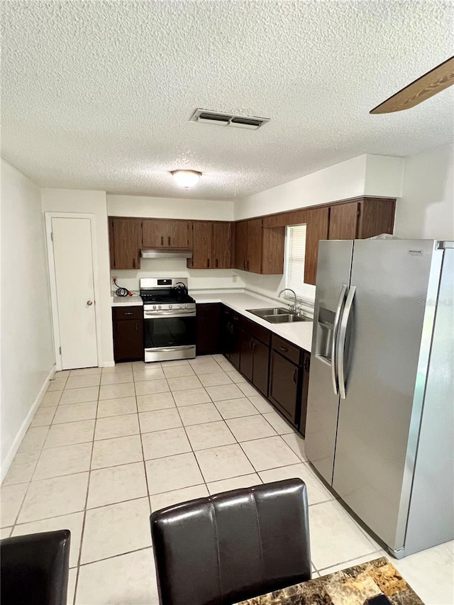 6789 SE 54th Ln, Ocala, FL 34472 - kitchen with stainless steel appliances, light countertops, a textured ceiling, light tile patterned floors, and under cabinet range hood