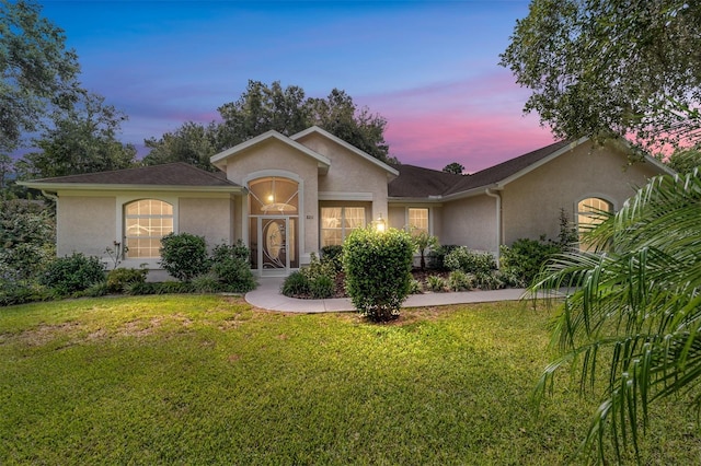 ranch-style home with a yard